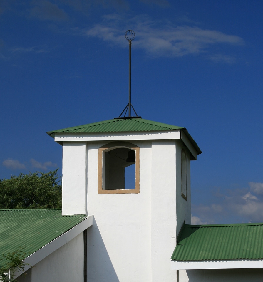 Whispy cloud green roof tops white walls