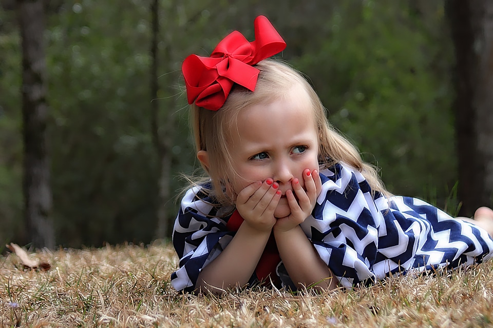 Little girl laying down outdoors