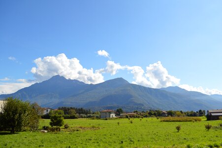 Clouds over mountain peaks landscape green meadows photo