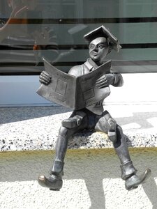 Small sculpture boy reading on the window sill photo