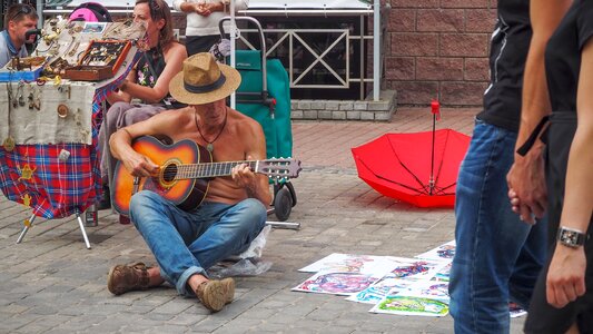 Man sitting on the pavement sale of souvenirs photo