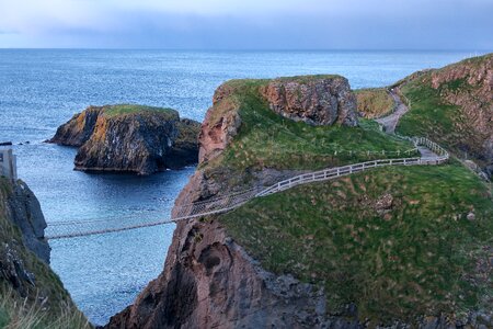 Suspension bridge rock sea photo