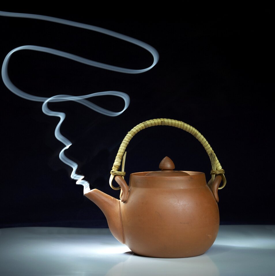 Tea pot with abstract white steam, close up