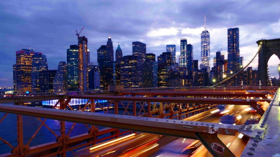 Cars speeding at sunset on Brooklyn Bridge, Manhattan.