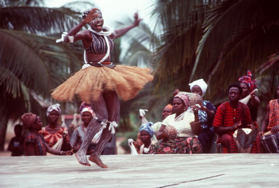 An African woman, wearing native garments, performs