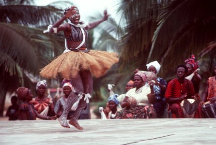 An African woman, wearing native garments, performs