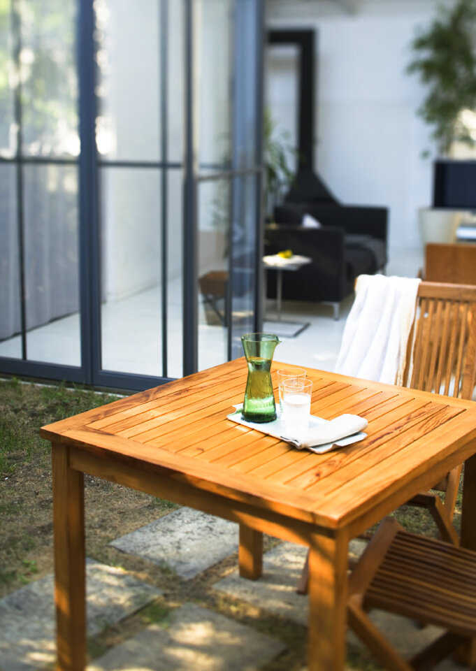 Glass of fresh water, on garden table.