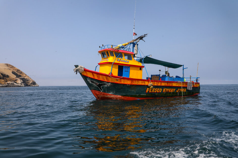 Fishing boat floating on the water, blue sea and sky