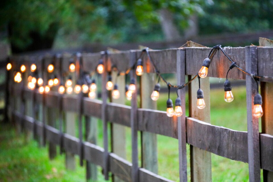 String of lights, exterior, yellow bulbs on old wooden Fence photo