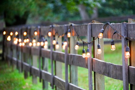 String of lights, exterior, yellow bulbs on old wooden Fence