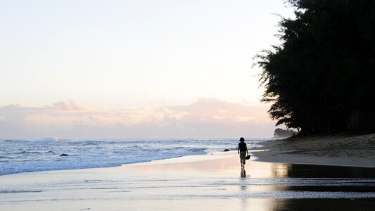 Silhouette of a person walking on the beach on Kauai photo