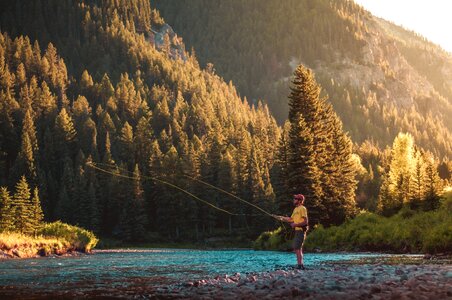 fly fishing angler makes cast