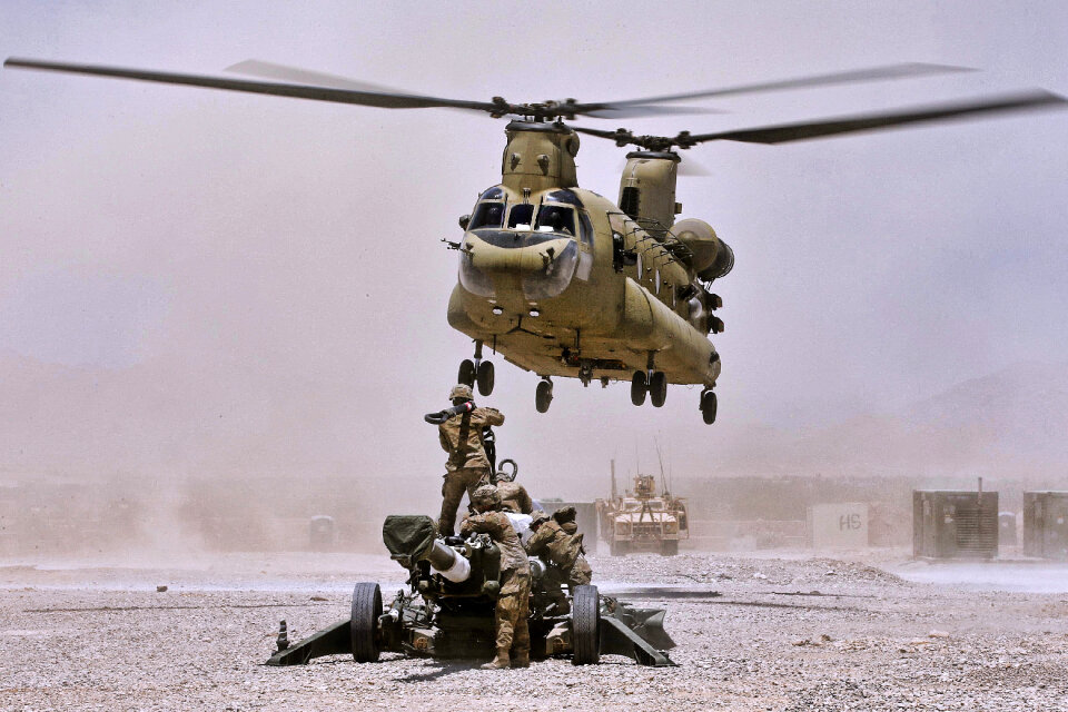 U.S. Soldiers hook-up a M777A2 howitzer to a CH-47