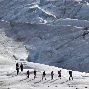 Group of people trekking on top of glacier