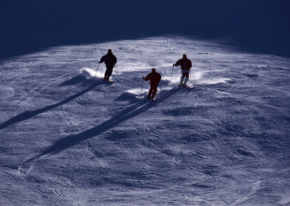 Alpine skier skiing downhill, blue sky on background