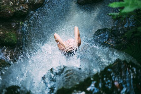 Girl showering in waterfall photo