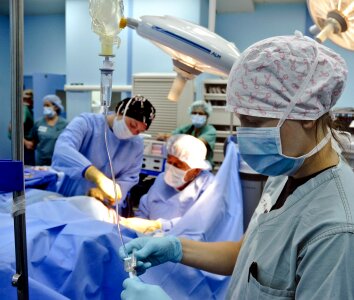 Group of surgeons looking at patient on operation table photo