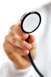 Hand holding a stethoscope on white background