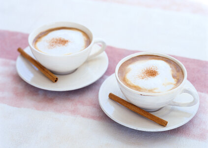 Two cups of coffee with cinnamon stick photo