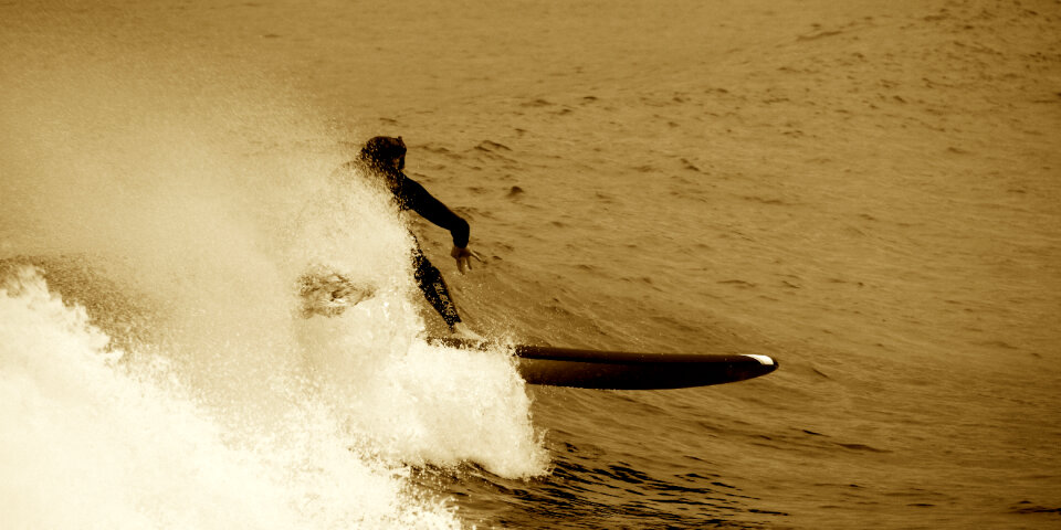 Surfing a Wave at Sunrise Time