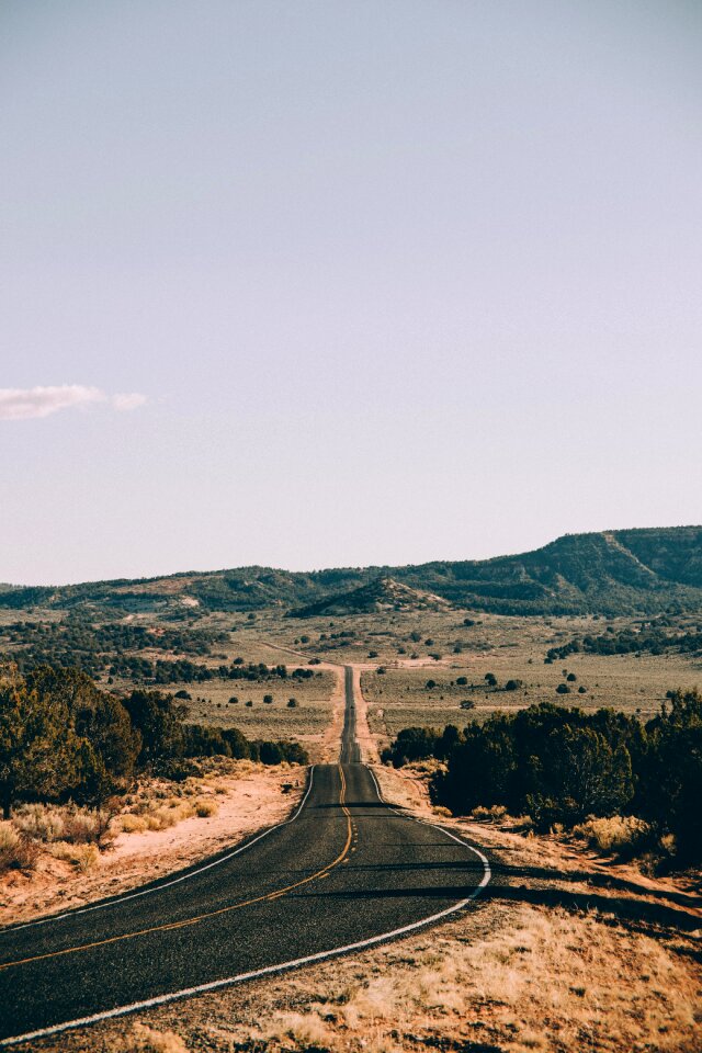 A long, straight highway cuts through the Arizona desert