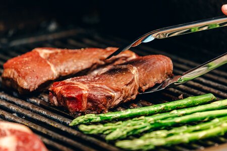 A Steak On A Grill About To Be Flipped