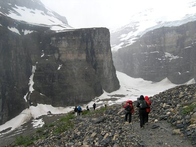 Hikers are climbing rocky slope of mountain photo