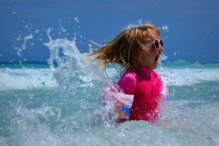 Little girl with surf board learning surfing photo