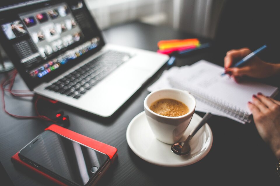 office table with notebook cup of coffee, tablet pc and notepad photo