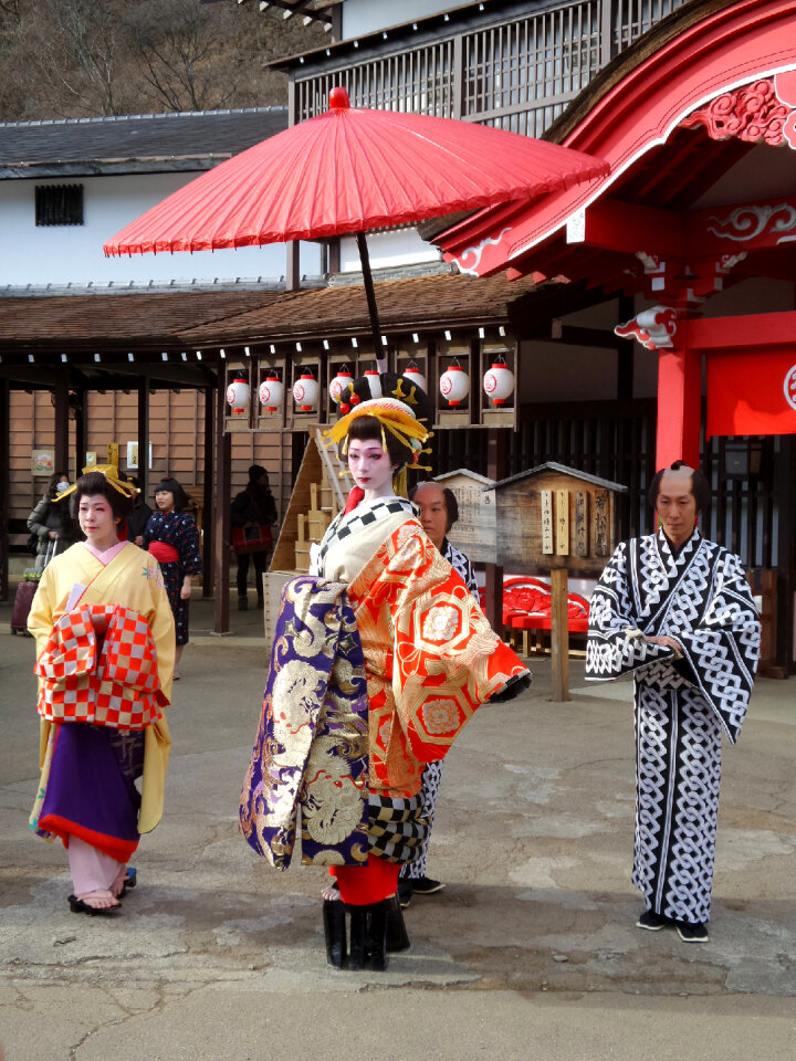 Three geishas walking on a street