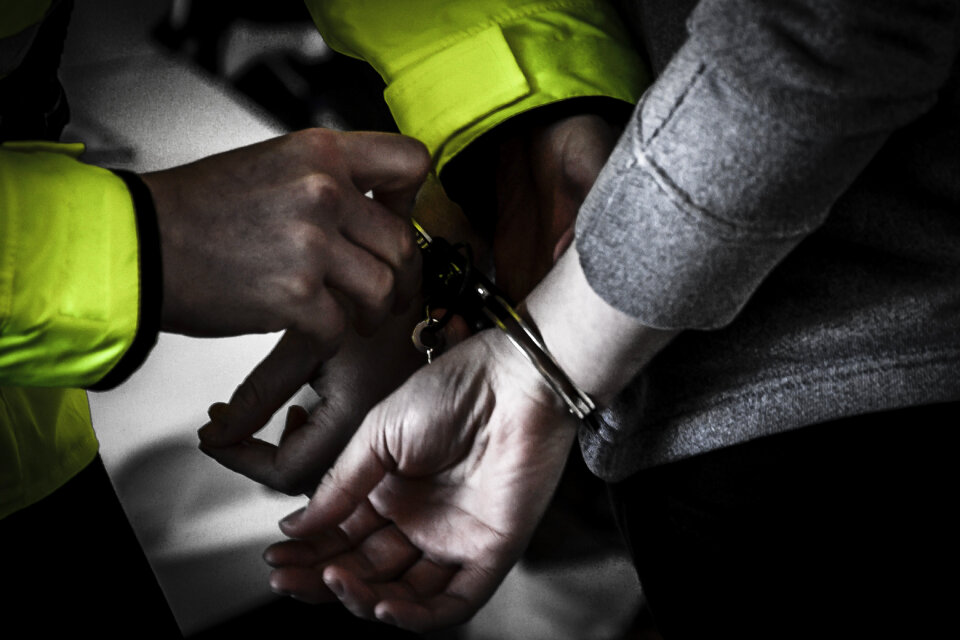Police Officer Arresting Young Man