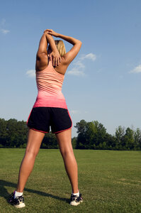 A Healthy Young Woman Stretching Before Exercise Outdoors photo