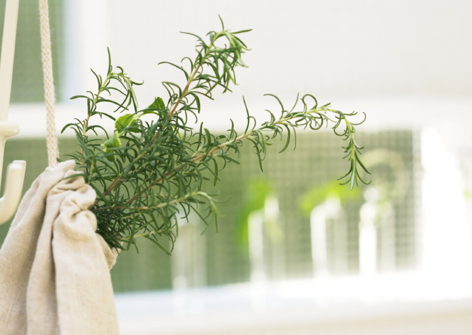 Rosemary bunch nestled inside a burlap bag tied with twine.