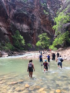 Group of tourists hiking in the cold river