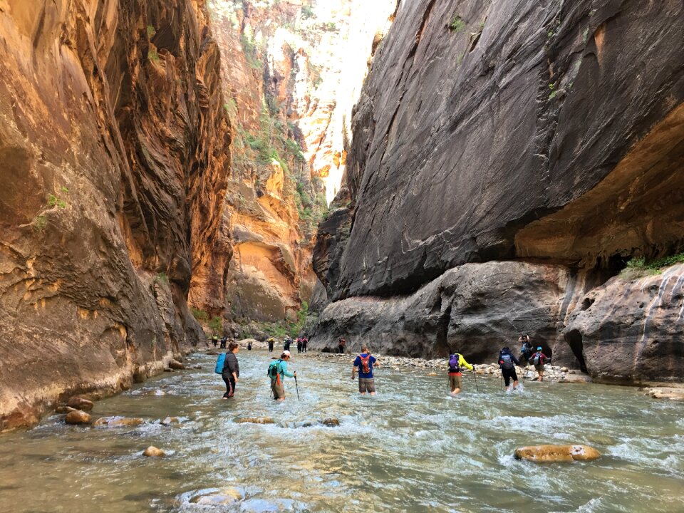 Group of tourists hiking in the cold river
