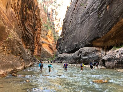 Group of tourists hiking in the cold river