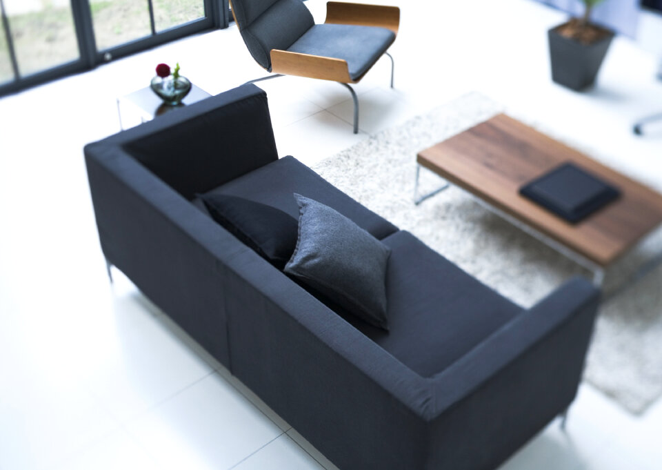 White living room with black leather sofa