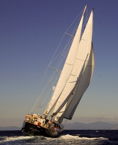 A boat with solitary captain sailing in the blue sea