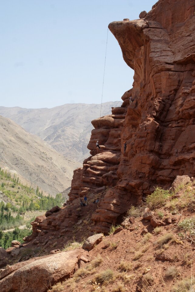 Young man climbing natural rocky wall photo