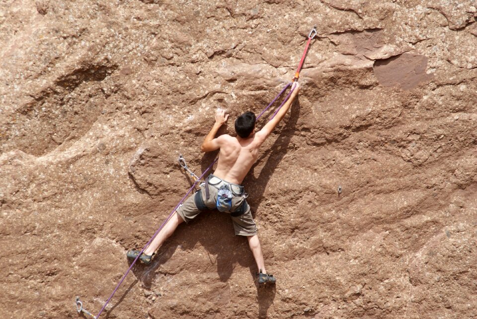 Young man climbing with wide valley photo