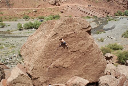 Young man climbing with wide valley