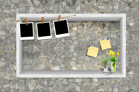 Blank photos hanging on a clothesline over brick wall background