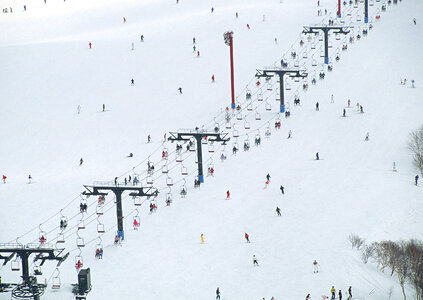 Skiers and snowboarders on a ski lift photo