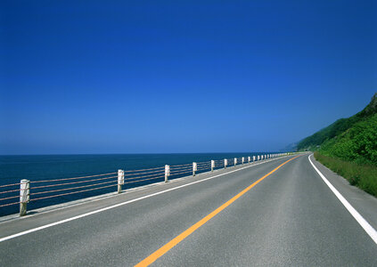 Turning mountain highway with blue sky and sea