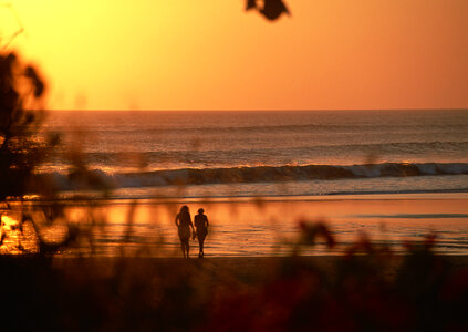 young happy couple at sunset beach photo