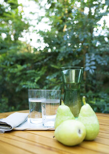 Two cup of water and fruit displayed on the table