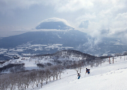 Two Skiers skiing downhill in high mountains
