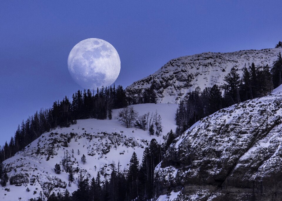 Full moon in the night sky in the mountains