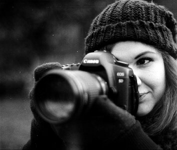 young woman photographing outdoors in winter photo