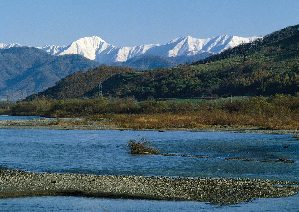 Fast river on green meadow. Large mountain valley.